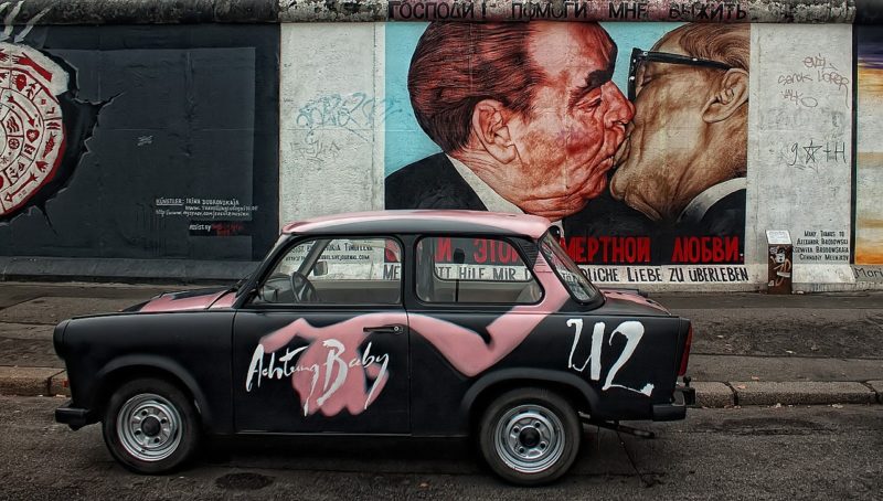 “The Kiss of Death.” It is perhaps the most famous image that appears in Berlin’s East Side Wall